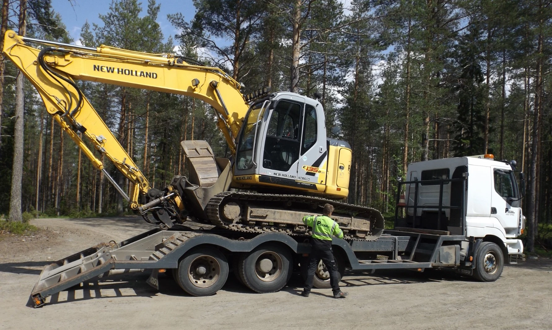 PEEAA Oy — kaivinkone kuljetuslavetilla suomalaisessa metsässä
